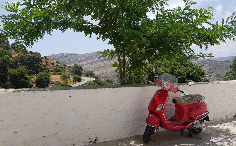 Naxos Greece: Travel Guide 2023 16 Phot of a red vesper and a low wall overlooking the mountain scenery in Apiranthas, Greece