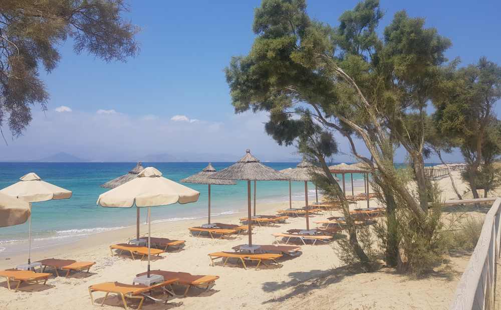Naxos Greece: Travel Guide 2023 10 Photo of umbrellas and sun loungers on Plaka Beach, Naxos, Greece